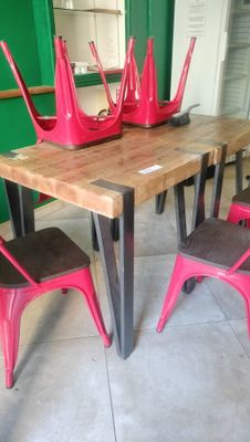 a wooden table with red chairs and a wooden table