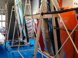 Plusieurs planches de surf sont alignées sur un support dans une pièce.