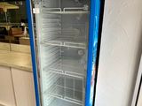 un réfrigérateur bleu posé dans un coin d'une pièce