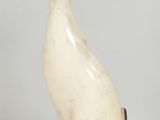 a white cat statue sitting on a white surface