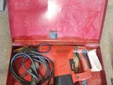 une boîte rouge posée par terre, contenant des outils