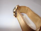 a close up of a gold bracelet with a diamond on it