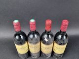 three bottles of wine are lined up on a black surface