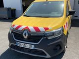 a yellow van parked in front of a building with a red and white stripe on it