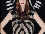 une femme coiffée d'une coiffe à plumes et posant pour une photo