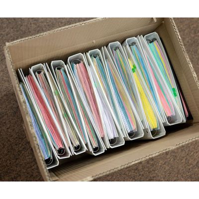 a cardboard box filled with lots of different colored papers