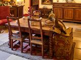 une salle à manger avec une table, des chaises et un buffet
