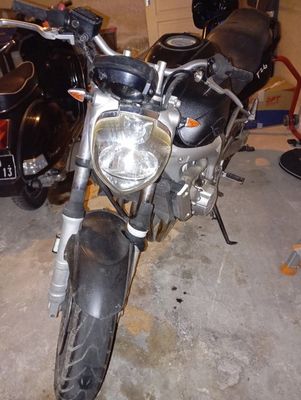 a black motorcycle parked in a garage next to a black car
