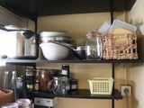 a black shelf with various items on it in a kitchen