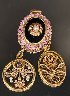 deux boucles d'oreilles dorées ornées de pierres noires et roses sur un fond noir