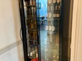 a glass case with bottles in it in a room