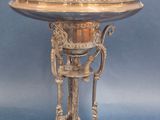an antique silver plate with a stand on a blue background