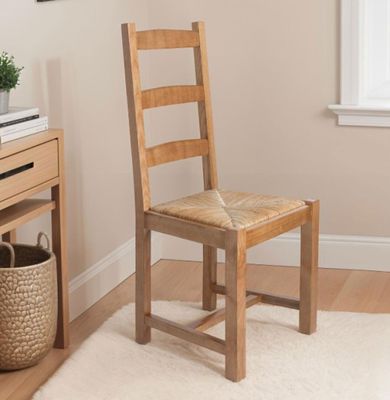 a wooden chair sitting in front of a desk with a basket on top of it