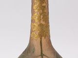 a glass vase with a flower on it sitting on a table
