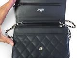 a person holding a black purse with a chain around it