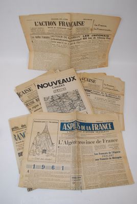 several old french newspapers sitting on top of a white table
