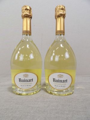 deux bouteilles de vin posées sur une table l'une à côté de l'autre