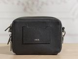 un sac photo en cuir noir posé sur une table en bois