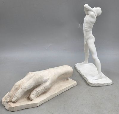 une statue représentant un homme tenant une batte de baseball, à côté d'une statue représentant une main tenant une batte de baseball