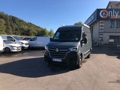une camionnette garée devant un immeuble devant lequel sont garées des voitures