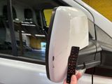 a person holding a remote control in front of a car