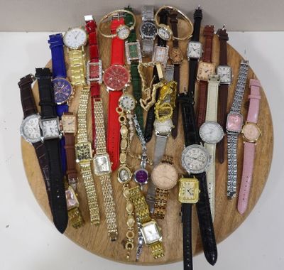 un plateau en bois sur lequel sont disposées de nombreuses montres différentes