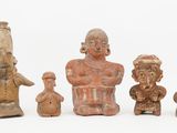 several clay figurines of different shapes and sizes on a white surface