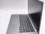 a silver laptop with a black keyboard on a white surface