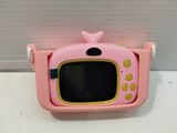 a small pink television set on a white surface