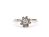 une bague en or blanc sertie de diamants en forme de fleur, sur fond blanc