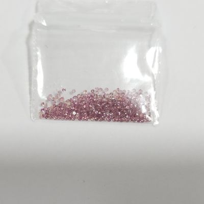 un petit sachet de paillettes roses posé sur une surface blanche