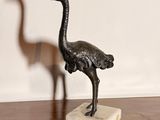 a statue of an ostrich and a bird on a table