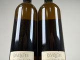 two bottles of wine sitting next to each other on top of a table