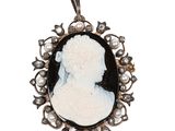 un camée ancien représentant une femme avec des perles dans les cheveux