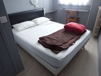 un lit recouvert d'une couverture marron dans une chambre
