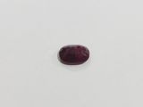 a red garnet stone on a white surface