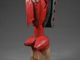 une sculpture en bois représentant le visage d'un homme coiffé d'un chapeau