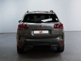 the rear end of a grey suv parked in a garage