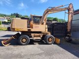 une photo d'un engin de chantier garé devant un immeuble