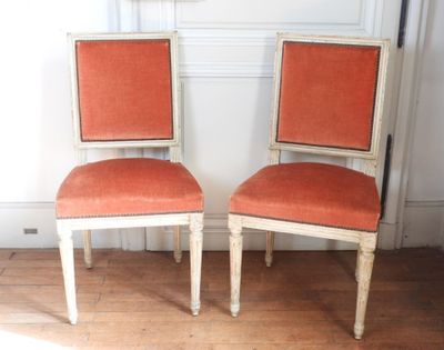 deux chaises assises l'une à côté de l'autre sur un sol en bois dur