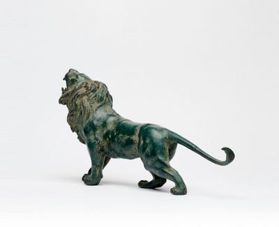 une statue de lion posée sur une surface blanche