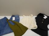three pairs of jeans and a jacket are on a white table