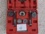 une boîte à outils rouge remplie d'outils, posée sur un sol en béton