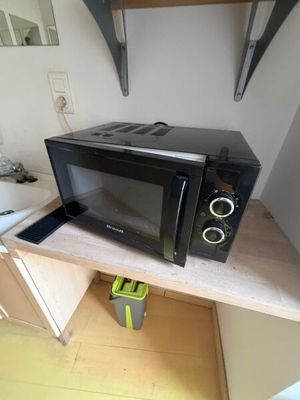 un micro-ondes posé sur une étagère dans la cuisine
