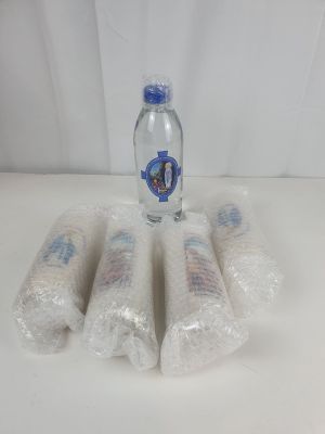 quatre bouteilles d'eau posées sur une table recouverte d'un film plastique