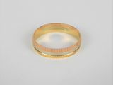 gros plan d'une bague en or sur fond blanc