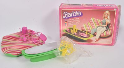 une poupée Barbie assise sur une chaise à côté d'une boîte à goûter