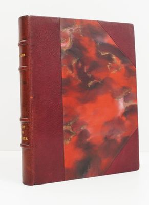 un vieux livre à la couverture rouge posé sur une table blanche