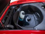 a red car with its hood open and a water bottle in the trunk