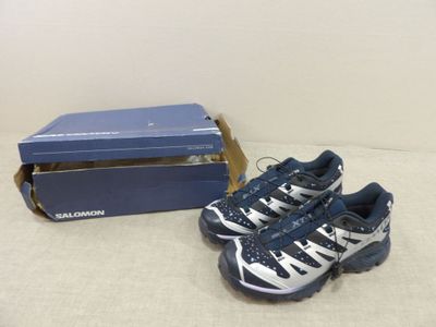 a pair of shoes that are on the ground next to a box